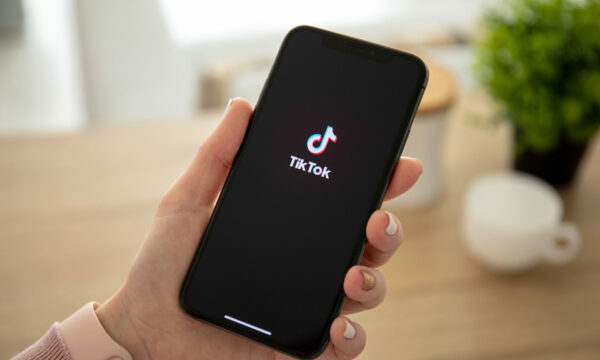 Woman holding iPhone X with streaming service media video TikTok